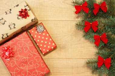 Yeni yıl / yılbaşı hediyeleri paket, ağaç ahşap arka plan şablonu üzerinde kırmızı yay ile