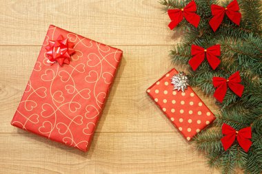 Yeni yıl / yılbaşı hediyeleri paket, ağaç ahşap arka plan şablonu üzerinde kırmızı yay ile