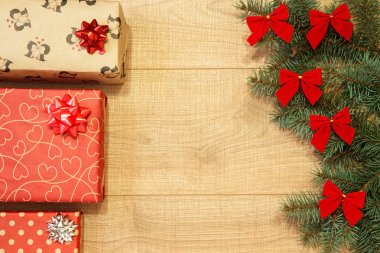 Yeni yıl / yılbaşı hediyeleri paket, ağaç ahşap arka plan şablonu üzerinde kırmızı yay ile