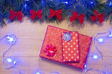 Yılbaşı / Noel hediyeleri paket, ağaç kırmızı ok ve mavi garland ahşap arka plan şablonu