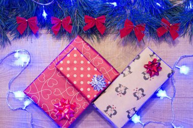 Yılbaşı / Noel hediyeleri paket, ağaç kırmızı ok ve mavi garland ahşap arka plan şablonu