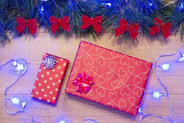 Yılbaşı / Noel hediyeleri paket, ağaç kırmızı ok ve mavi garland ahşap arka plan şablonu