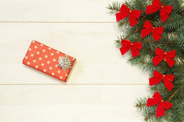 Yeni yıl / yılbaşı hediyeleri paket, ağaç ahşap arka plan şablonu üzerinde kırmızı yay ile