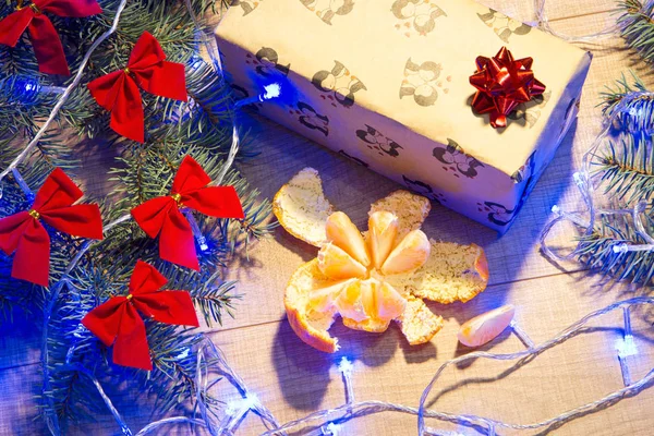成熟的桔子 圣诞树与红色弓 礼物在包装和蓝色花环在木背景模板 — 图库照片