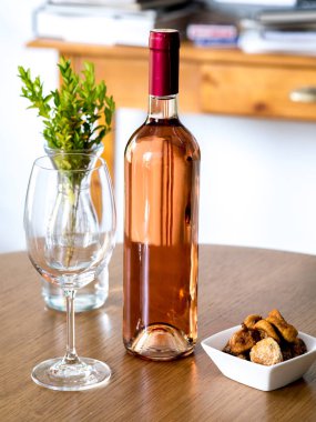 Şarap kadehi ve masada şarap şişesi