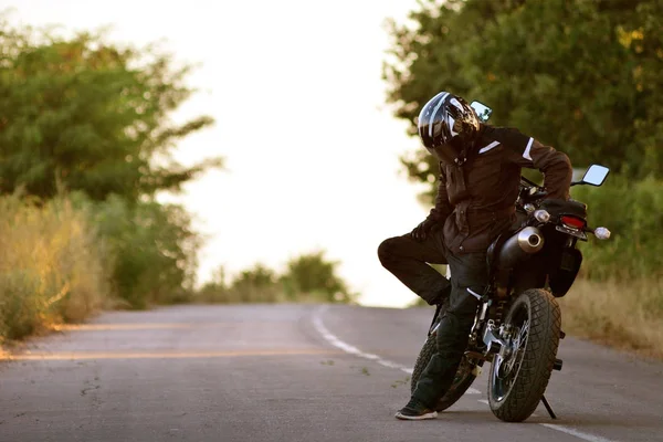 Motociclista solitario con casco mirando al suelo. Declaración lírica con un motero reflexivo . — Foto de Stock