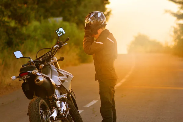 Der Motorradfahrer hält an und nimmt den Helm ab — Stockfoto