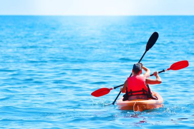 Bir kayık Denizi üzerinde kırmızı hayat ceketli çocuk yelken. 