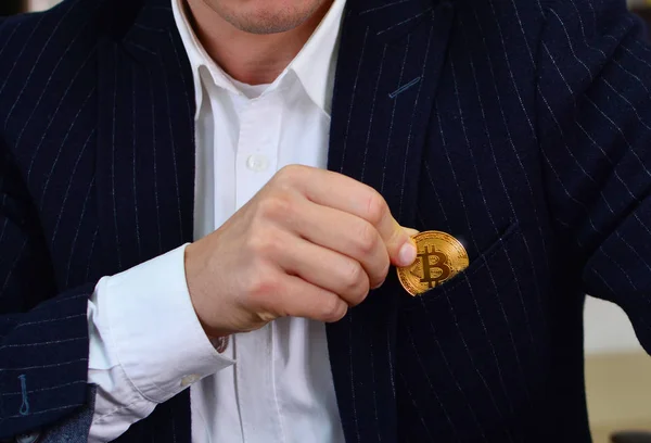 Elegante zakenman zet bitcoin in zijn jaszak — Stockfoto