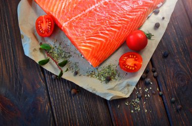 İştah açıcı parça domates ve baharat bir ahşap dokulu tablo ile dekore edilmiş somon.