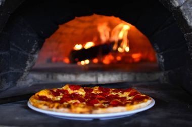 Bir İtalyan restoranı bir taş yangın fırın pizza.