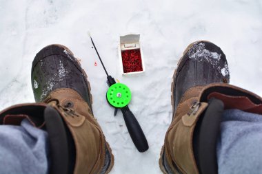 Winter fishing background. Shoes of a fisherman. clipart
