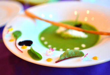 Güzel bir tasarım ile beyaz bir tabak içinde avokado krem çorbası. Gluten free gıda. 