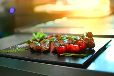 Salata ve kayrak taşı üzerinde et lezzetli yemek standı bir restoran bir profesyonel mutfağı paslanmaz çelik masaya