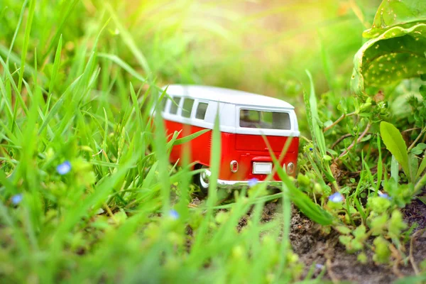 Bus trip. Adventure and holiday concept. Miniature toy bus in the middle of a tall grass.