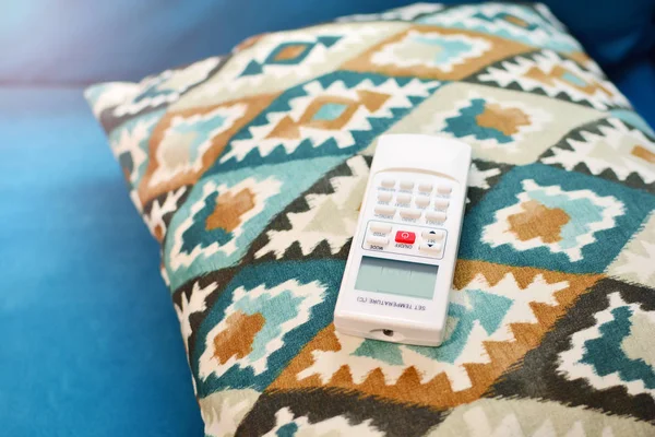 Air conditioner remote control lies on the sofa