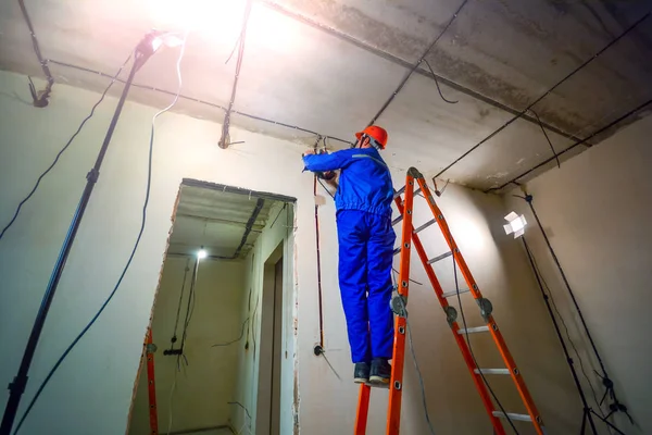 Eletricista Uma Escada Instala Fiação Teto — Fotografia de Stock