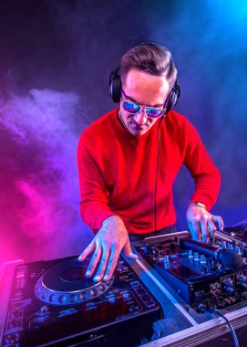 Genç DJ gece kulübünde pikapta oynuyor, dikey oryantasyon.