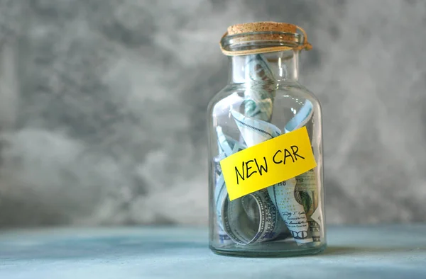 Rent. Money for new car concept with glass jar labeled new car filled with money.