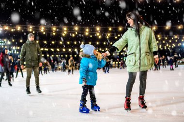 Street skating rink. Family at the ice rink. 