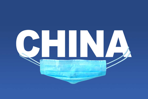 Coronavirus in China concept with text and medical protective mask on a blue background. 