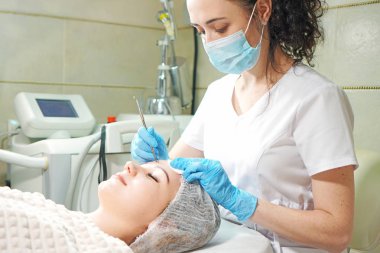 Kozmetik uzmanı hastaya mekanik yüz soyma tedavisi uyguluyor.