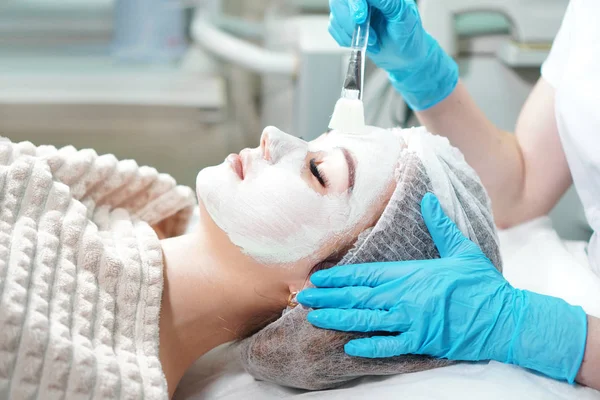 Cosmetólogo Haciendo Tratamiento Cosmético Mascarilla Facial Para Mujer Joven — Foto de Stock