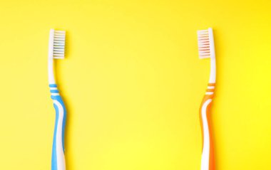 Sarı arka planda diş fırçası. Diş fırçaları birbirine bakar. Diş Konsepti. 