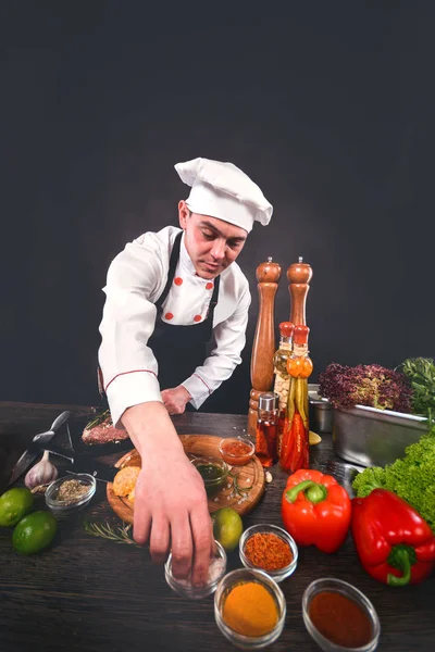Young chef cooking in a cuisine. Vertical composition.