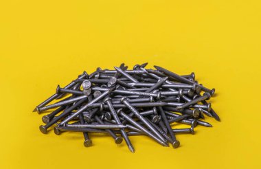Sarı arka planda inşaat çivileri. Makro fotoğrafçılık. 