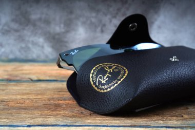 KHARKIV, UKRAINE - 12 Mart 2020: Deri çantadaki Ray-Ban güneş gözlüğü parçasının aydınlatıcı yazısı