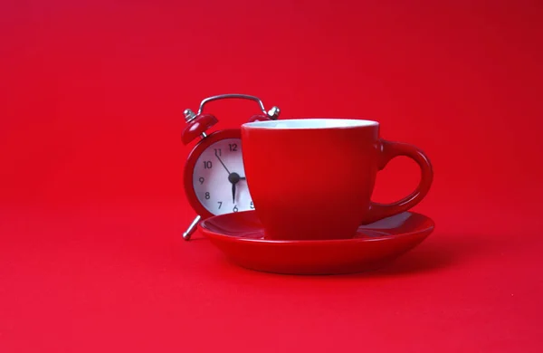 Roter Wecker Und Eine Tasse Kaffee Auf Rotem Hintergrund — Stockfoto