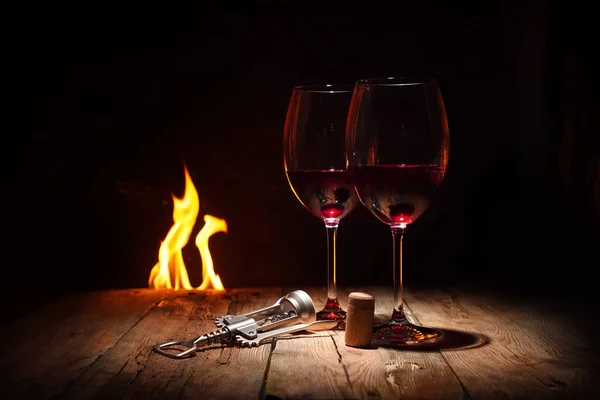 ロマンチックな夜の背景 暖かい暖炉の前に赤ワインと2つのワイングラス — ストック写真