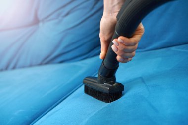 Elektrikli süpürgeyle kanepe temizliği. 