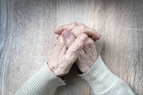 Gammal kvinna handflator på bordet. Ovanifrån — Stockfoto