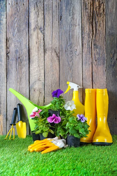 푸른 인공 풀을 심을 수있도록 화분에 심을 수있는 정원 도구와 꽃들. — 스톡 사진