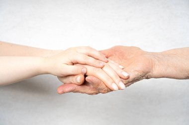 Birkaç kuşak konsepti. Torun ve annenin eli büyükannenin elinde yatıyor.