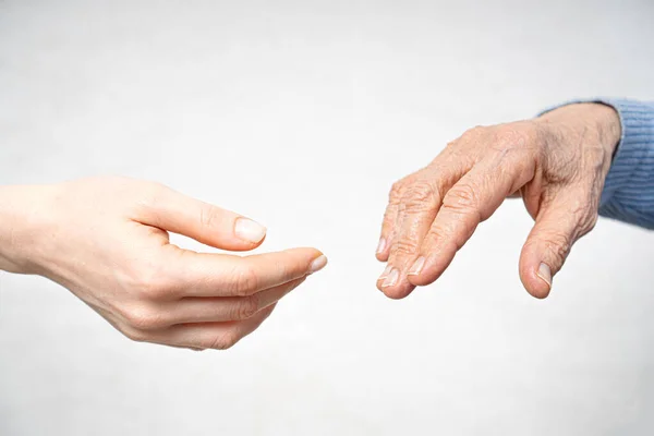 Mano de ayuda para el concepto de anciano con mano joven y mano vieja — Foto de Stock