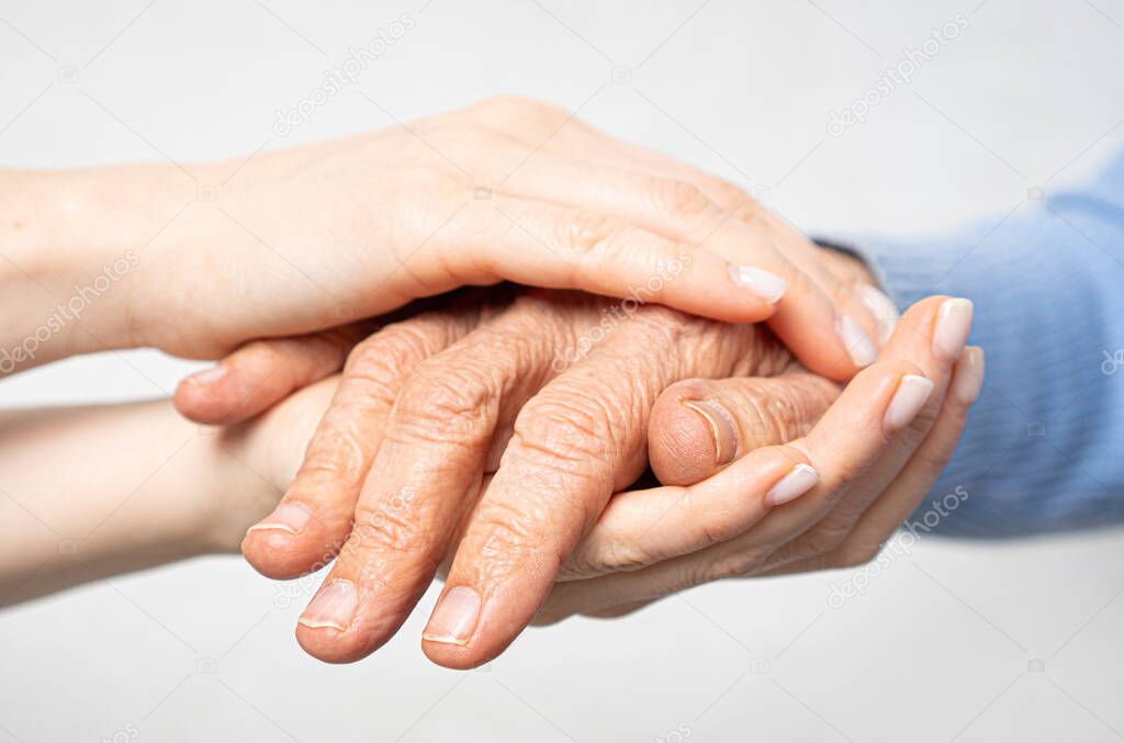Young hands hold old hands. Support for the elderly concept 