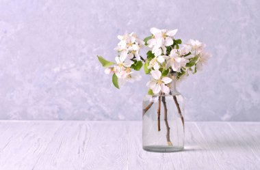 Çiçek açan elma ağacının bahar dalları ahşap masada cam bir kavanozda.