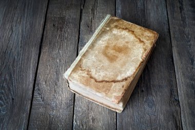 Ahşap arka planda boş kapağı olan eski bir antik kitap. Boşluğu kopyala