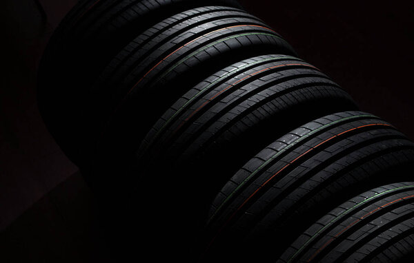New tires in a row on a dark background 