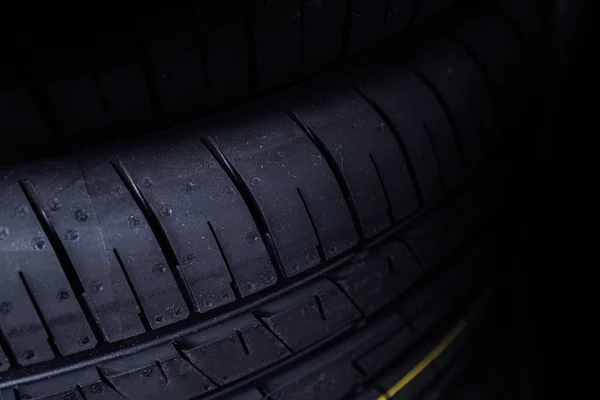 Fundo de pneu novo. Fragmento do pneu no fundo escuro — Fotografia de Stock