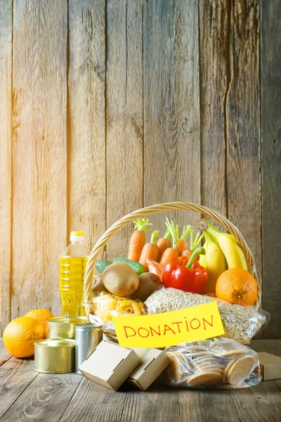 Food donation basket with different products and vegetables in a basket with text Donation. Vertical composition — Stock Photo, Image