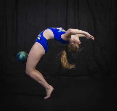 Jimnastikçi topu ile çalışmaları gerçekleştirir.