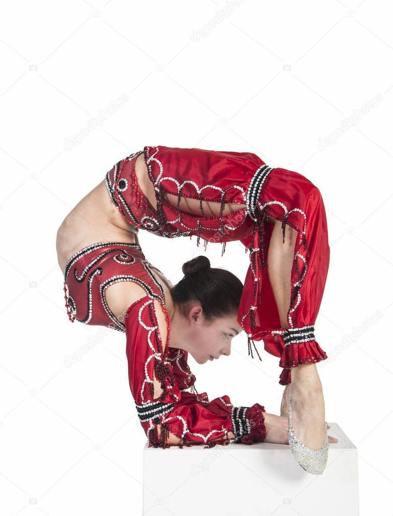 A young contortionist,circus performer in a red suit.