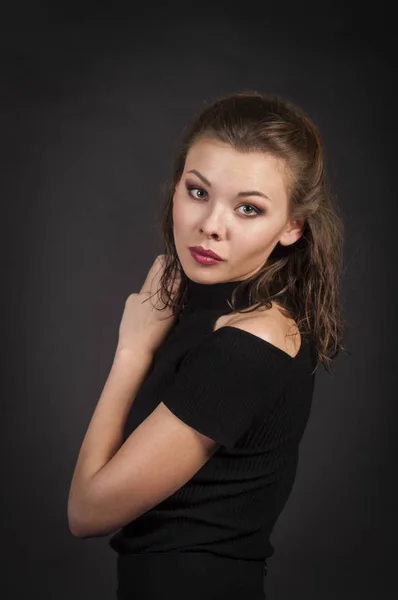 Retrato de uma menina em um fundo escuro . — Fotografia de Stock