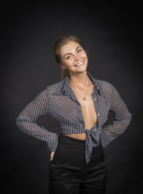 Duygusal kız bir gömlek ve siyah pantolon koyu arka plan üzerinde poz.