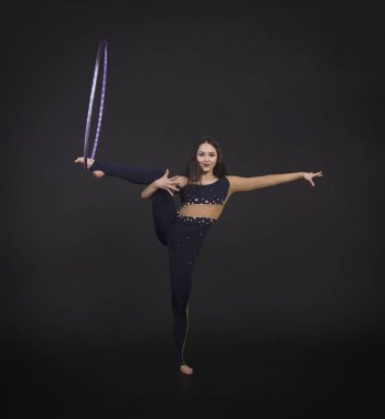 Hula Hoop kız ile jimnastik çalışmaları gerçekleştiren bir sirk sanatçısı.