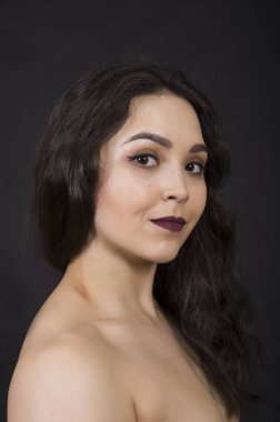 Karanlık bir arka planda bir kızın portresi.